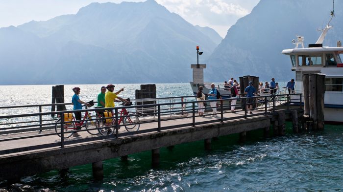 Cyclotouristes sur un ponton sur le Lac de Garde pendant leurs vacances à vélo en Italie