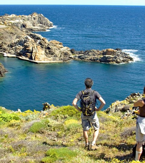 Marcheurs font une halte pour admirer le paysage sur un sentier escarpé de bord de mer en Corse