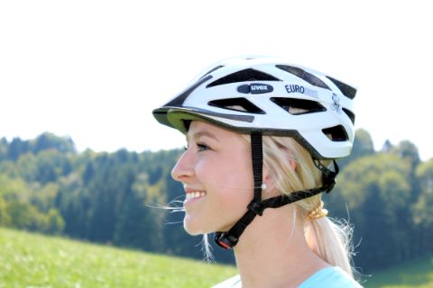 Jeune femme posant pour montrer le bon ajustement d'un casque vélo
