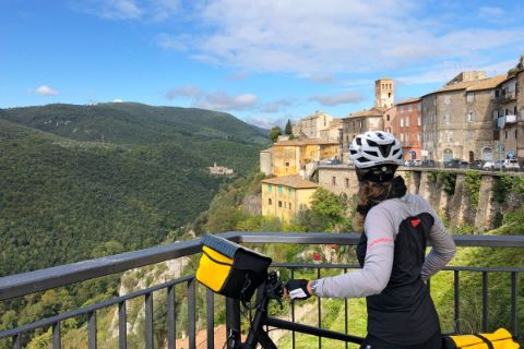 Cycliste observe un panorama impressionnant pendant ses vacances à vélo entre Florence et Rome