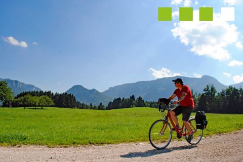 Un cyclotouriste sur un chemin entouré de montagne entre Munich et le Lac de Constance